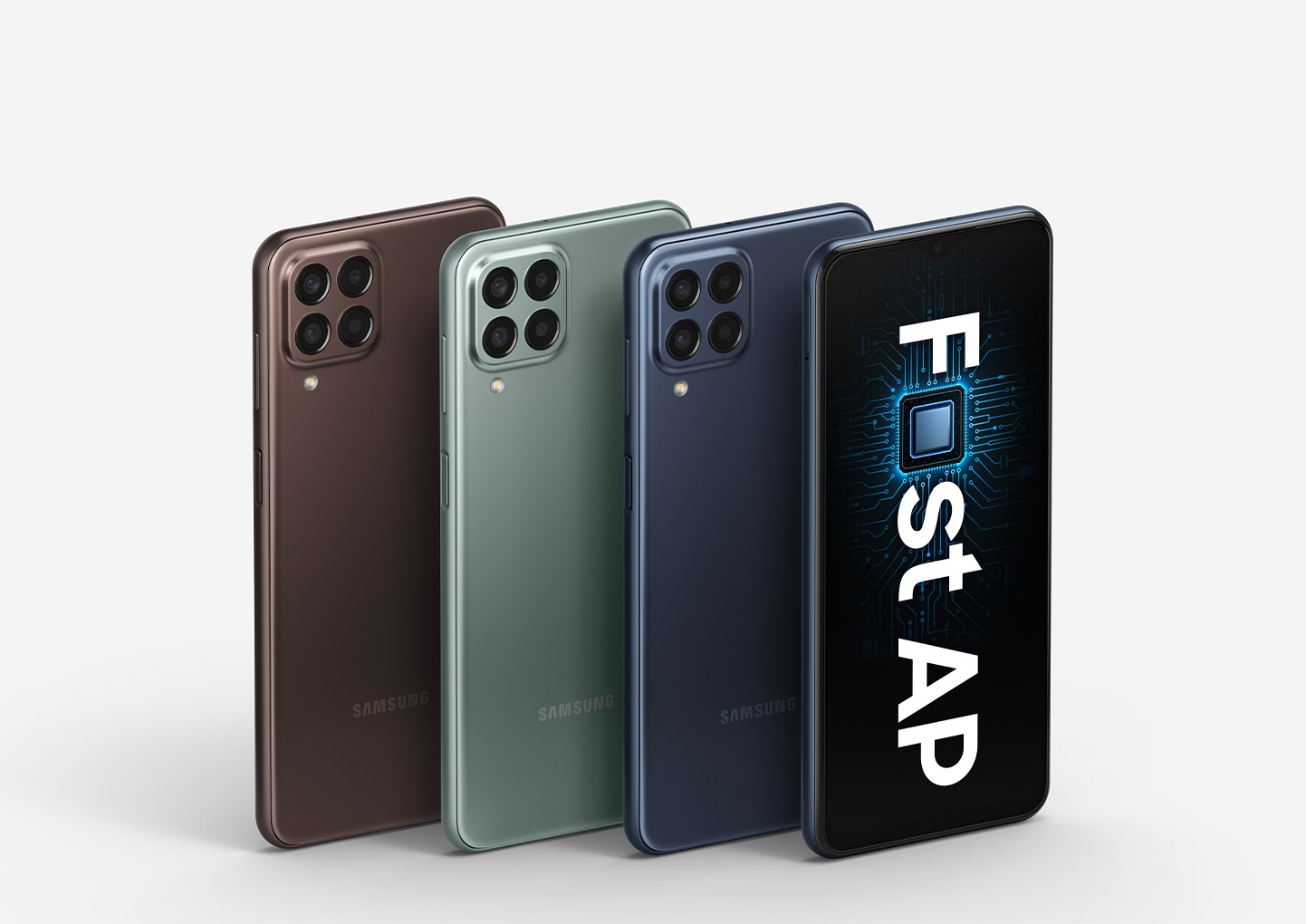 Four Galaxy M33 5G devices are shown with three of them showing the backside to display the Brown, Green and Blue colorways. The only front-facing device, located on the right edge, shows text that reads Fast AP with the a in Fast replaced with a processing chip.