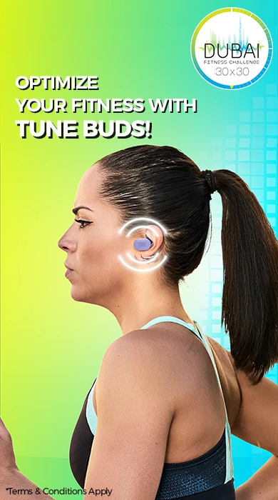 Woman wearing JBL Tune Buds wireless earbuds with Dubai Fitness Challenge 30x30 logo on a vibrant background