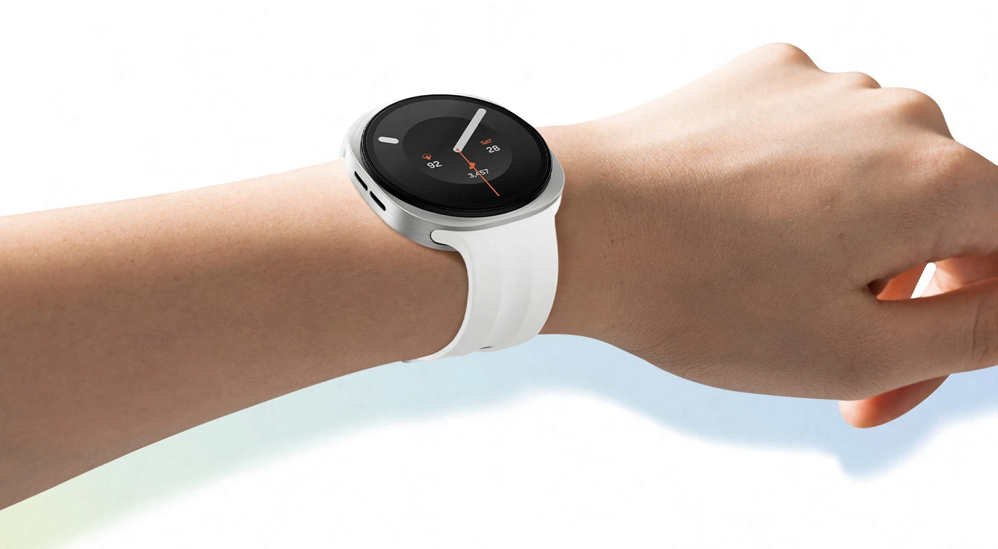 Galaxy Watch9 in Cream with a Sport Band in Cream worn on a person's wrist angled slightly to the right, showcasing the slim and smooth look of the watch with the signature cushion design, as well as the thin and flexible Sport Band for a snug, comfortable fit throughout the day with minimal gap thanks to the Dynamic Lug System.