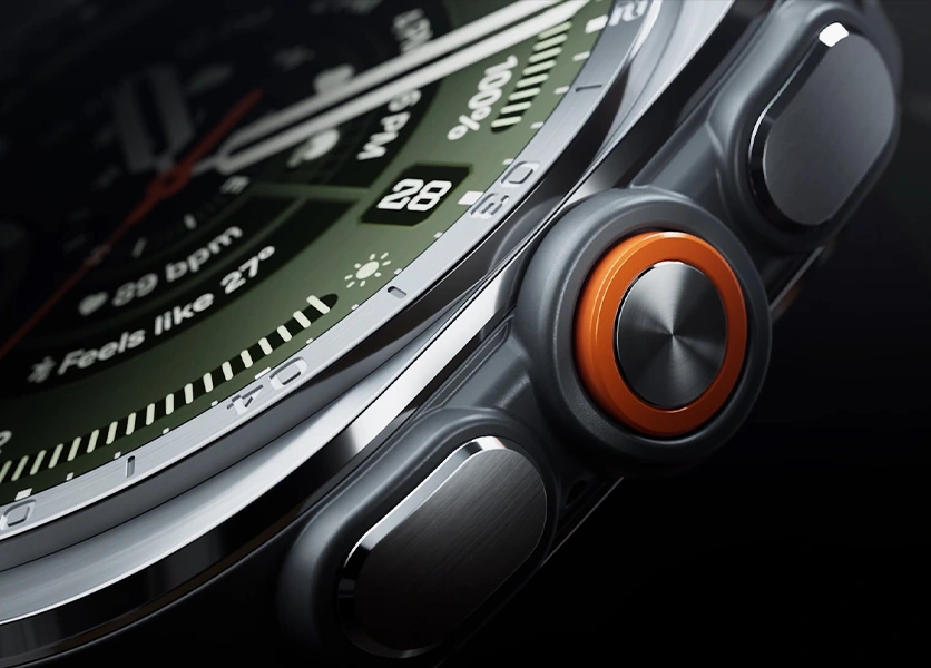 Close-up view of the boldly designed, intuitive buttons and the orange Quick Button on the side of a Galaxy Watch Ultra2 in Titanium Silver with a Marine Band in Olive, shown at an angle.