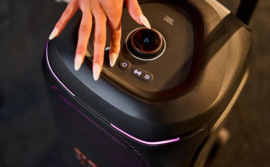 Close-up of a hand using the JBL PartyBox 330 top control panel and central dial