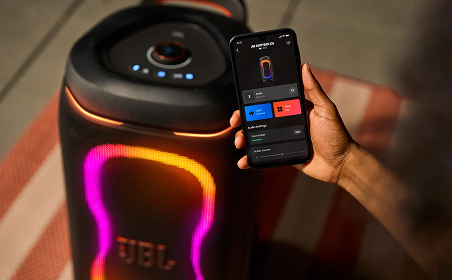 Person controlling the JBL PartyBox 330 sound and lighting through the JBL One app